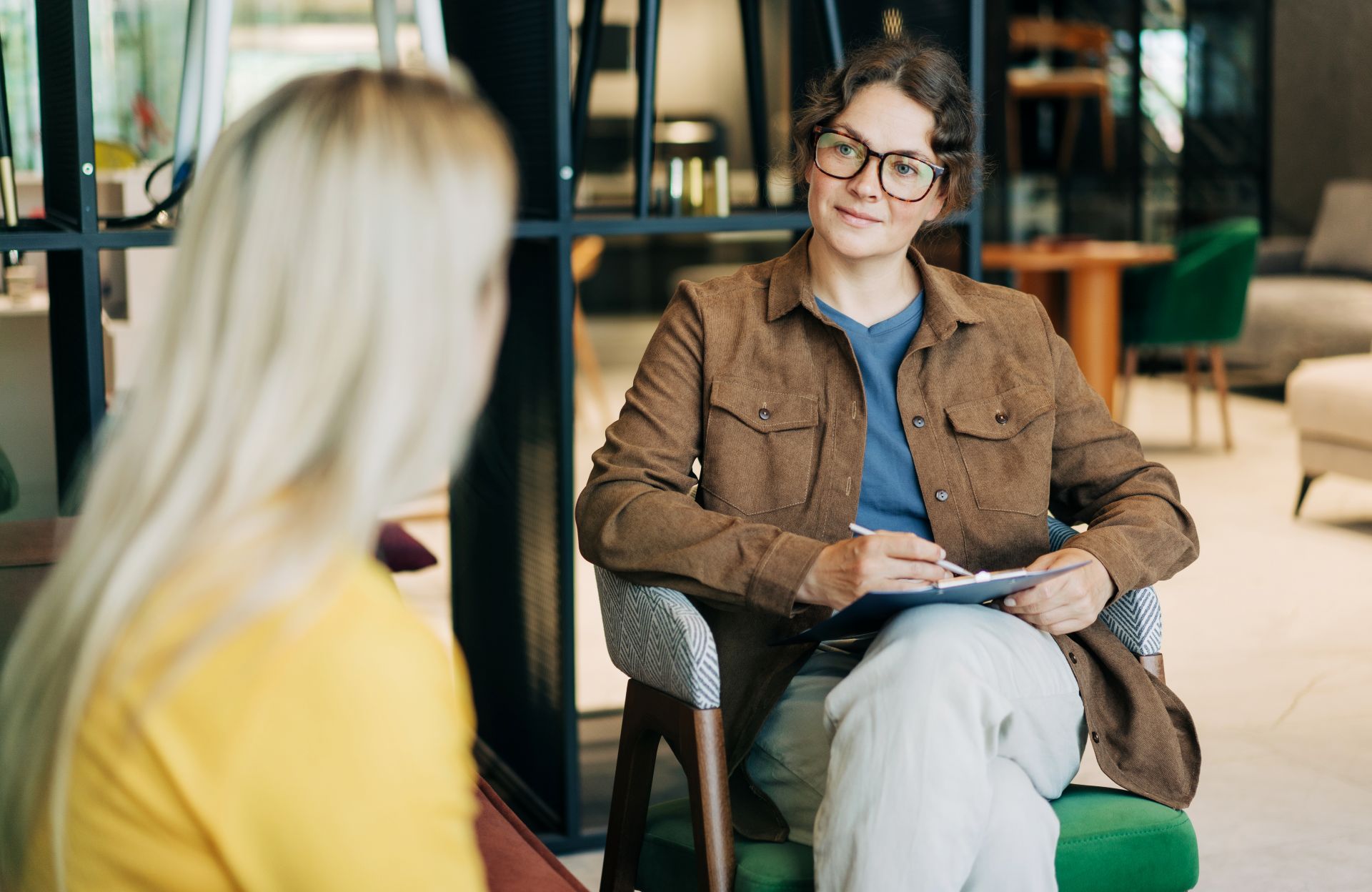 Frau im Gespraech mit Kollegin bei Interview ueber digitale Transformation und Online Seminarverwaltung
